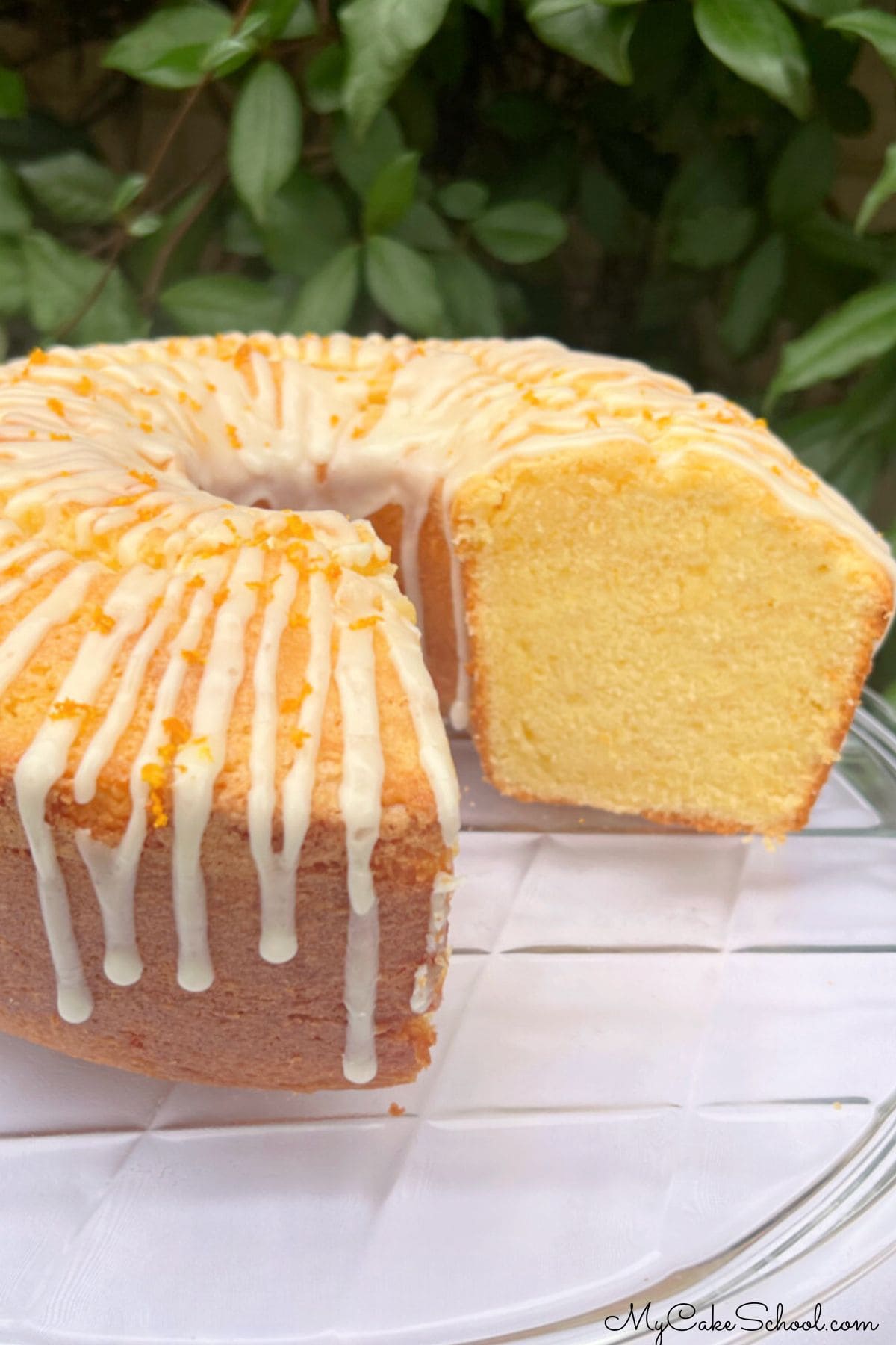 Orange pound cake, sliced, on a cake pedestal.