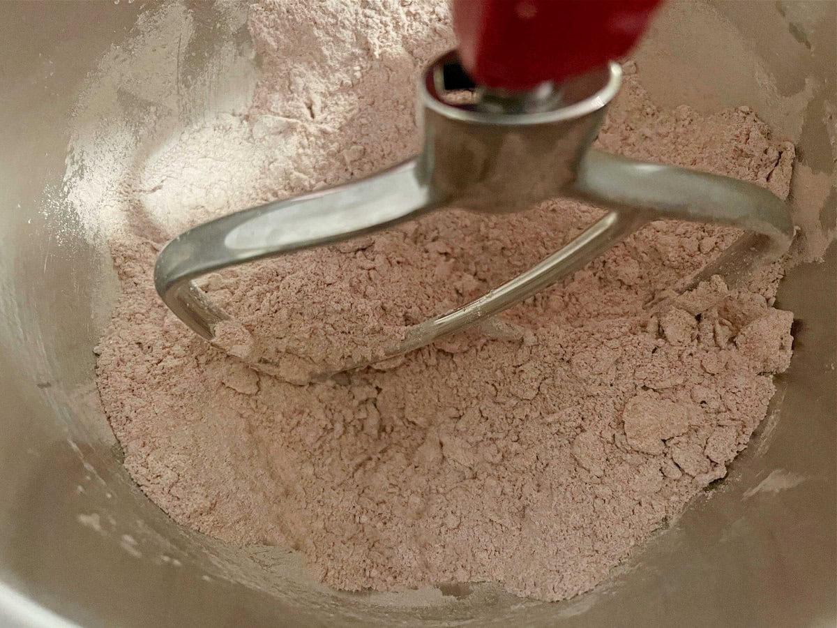 Dry ingredients mixing with butter in mixing bowl.