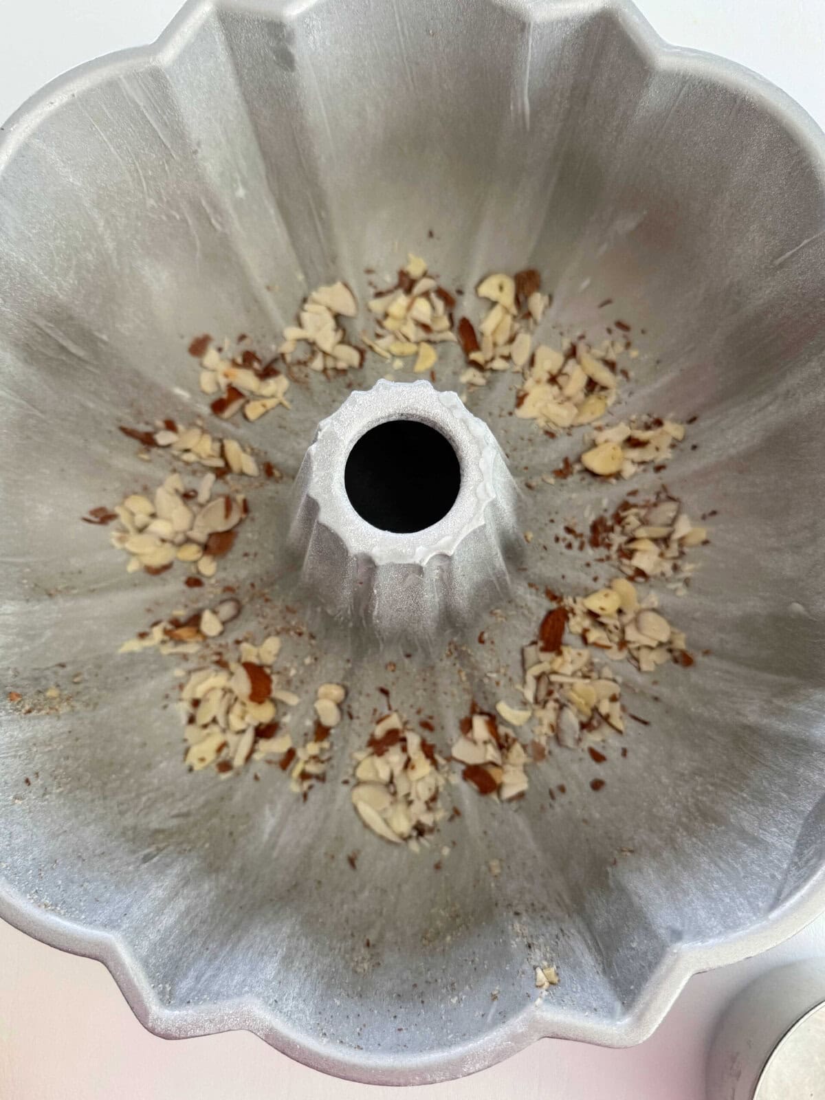 Sliced almonds sprinkled at the bottom of prepared bundt pan.