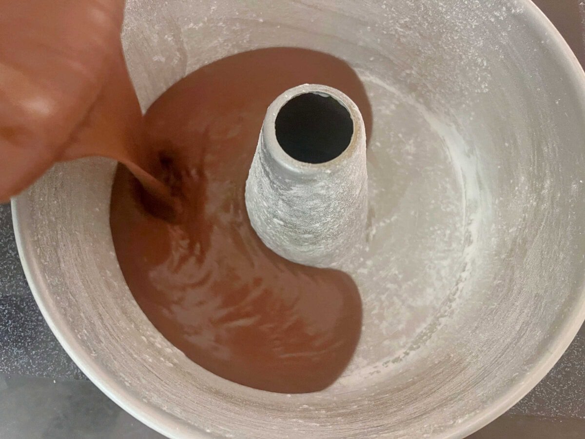 Pouring cake batter into the prepared cake pan.