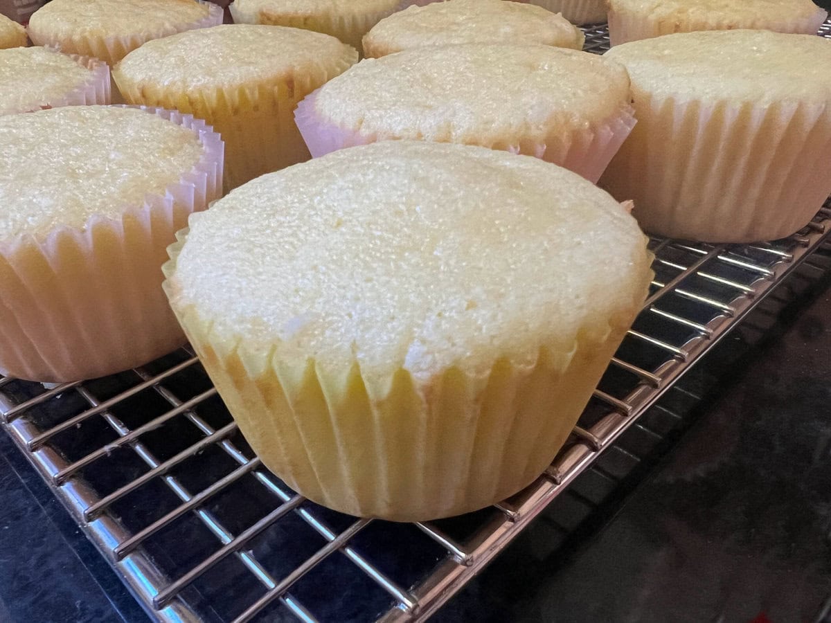 lemon coconut cupcakes cooling on a rack.