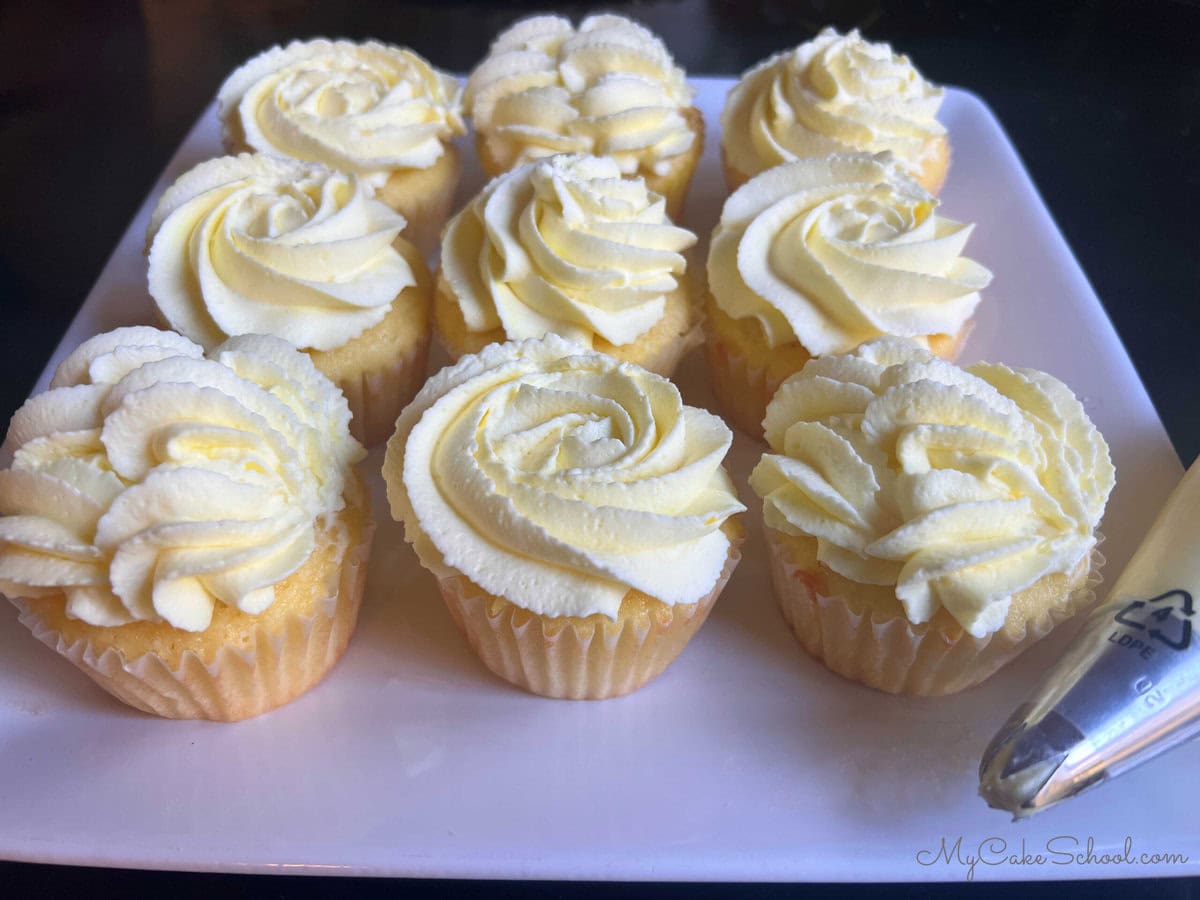 Lemon Sour Cream Cupcakes on a cake plate.