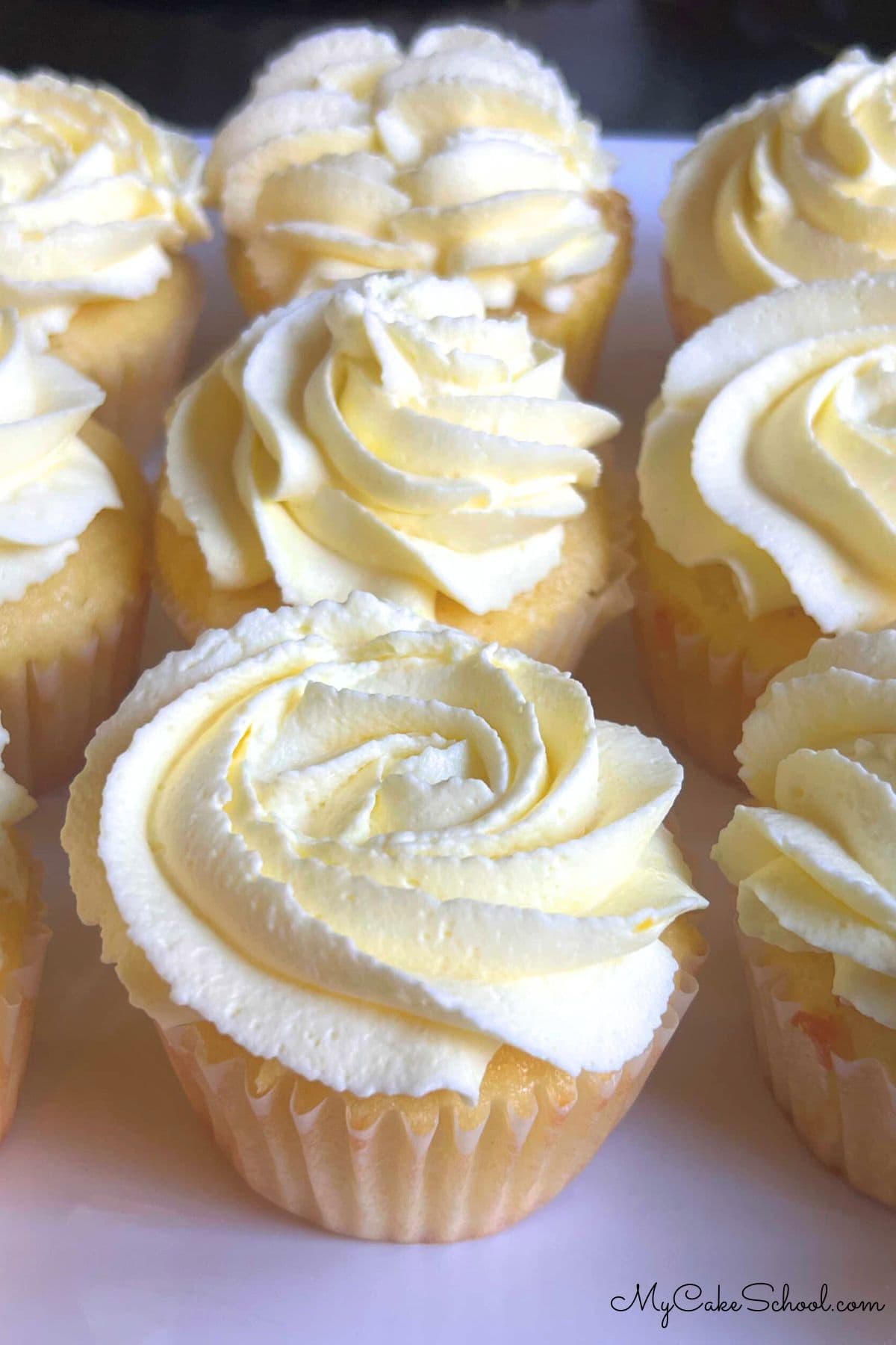 Lemon Sour Cream cupcakes on a cake plate.