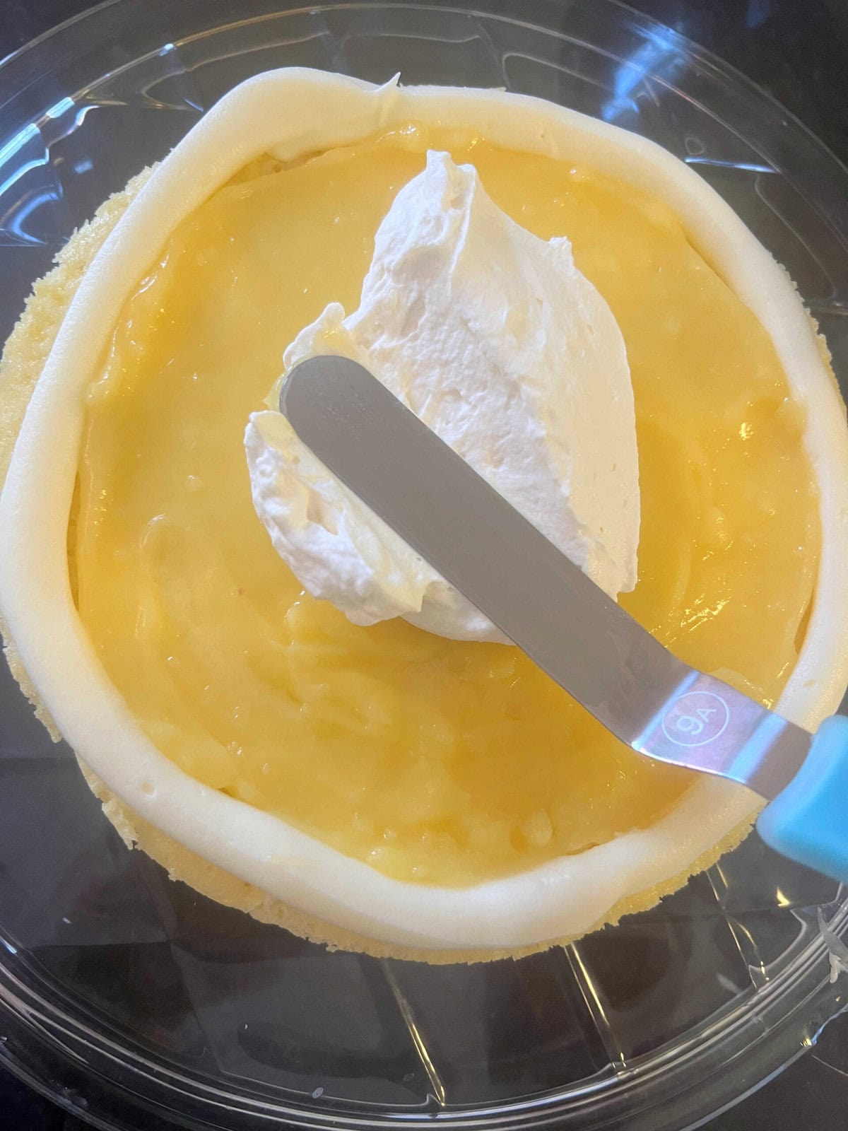 Adding filling to the Key Lime Cake Layers.