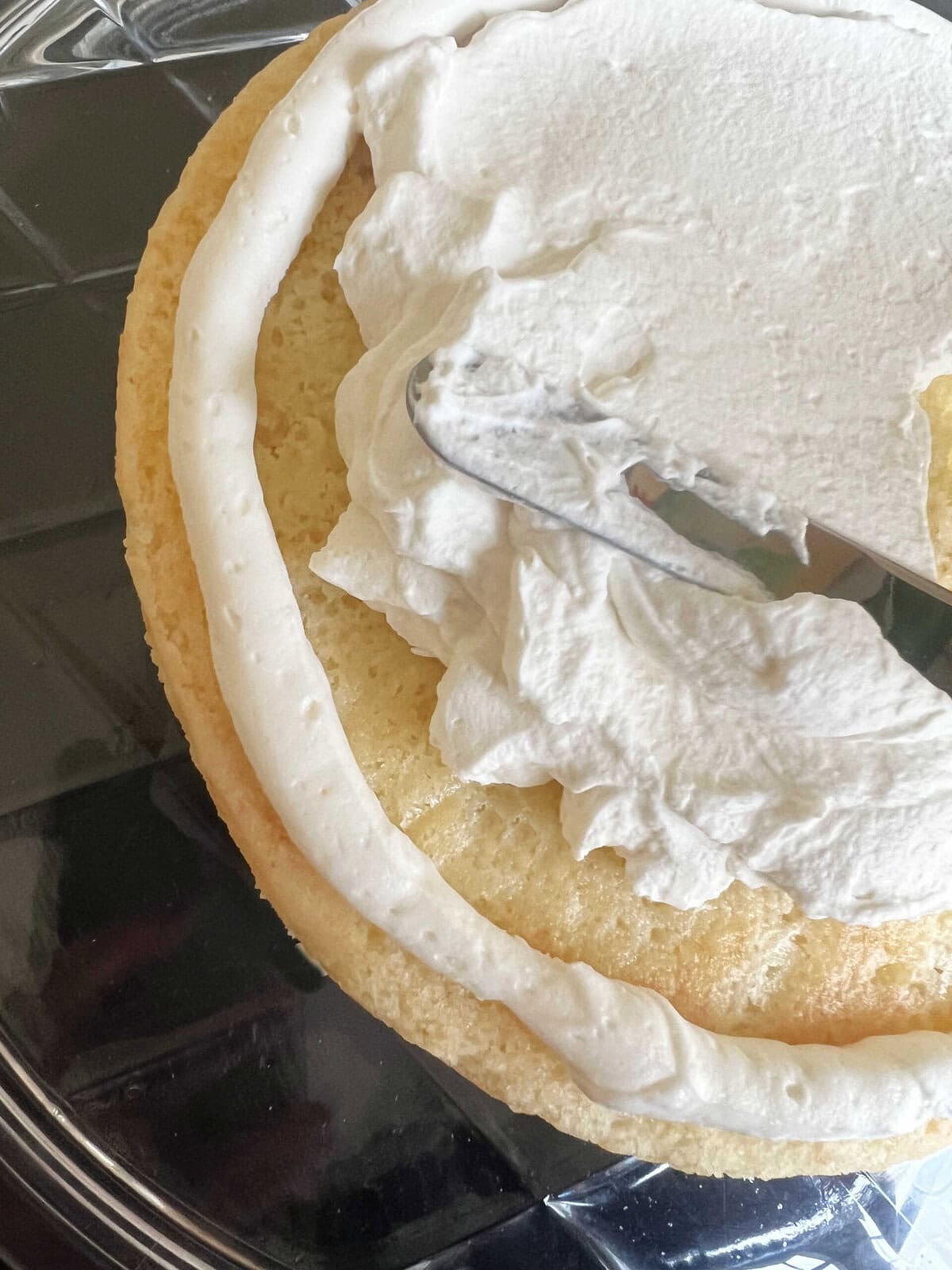 Filling the cake layers with whipped cream.