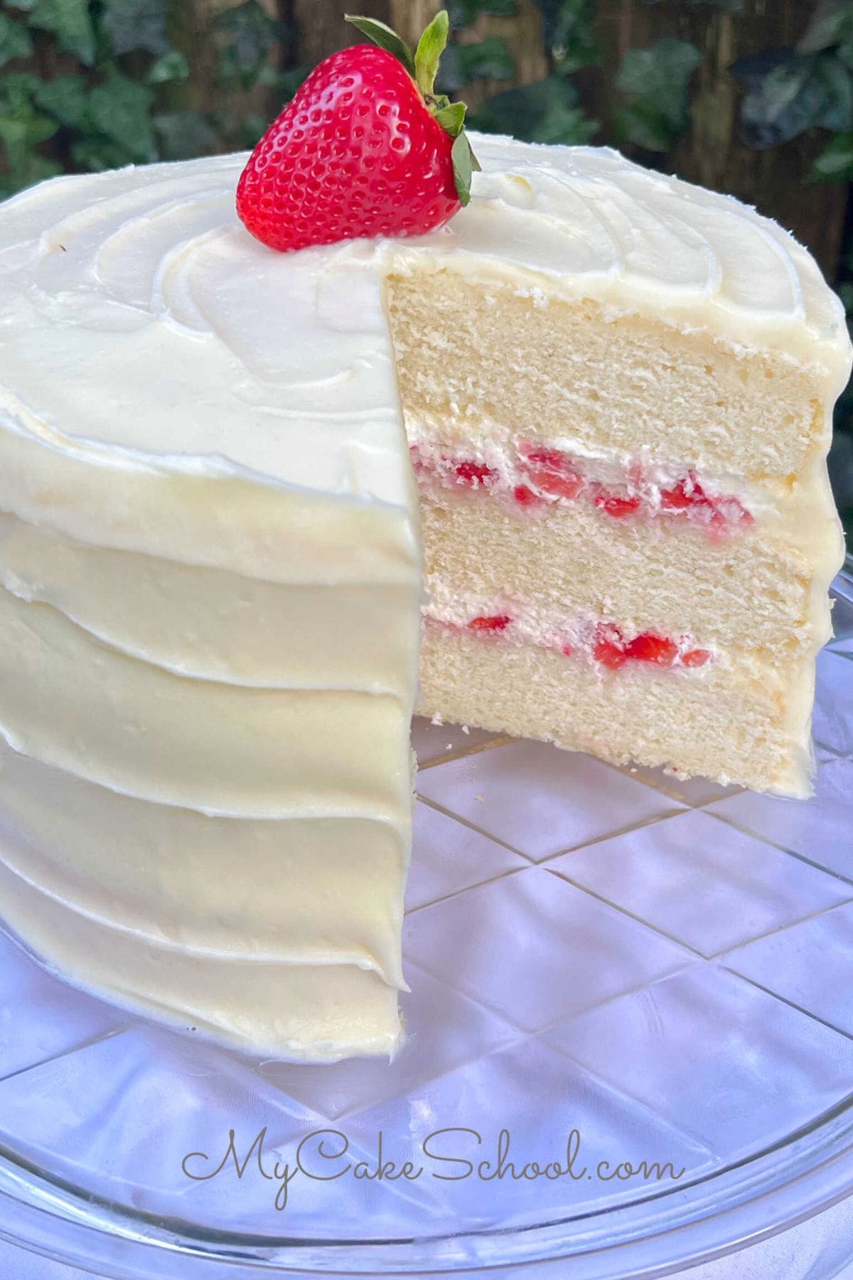 Strawberries and Cream Cake, sliced, on a cake pedestal.