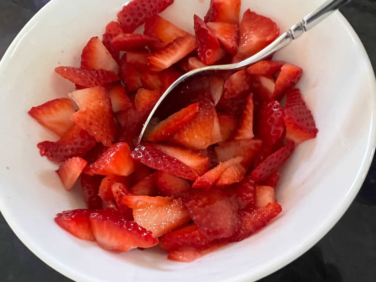 Sliced strawberries in a bowl.